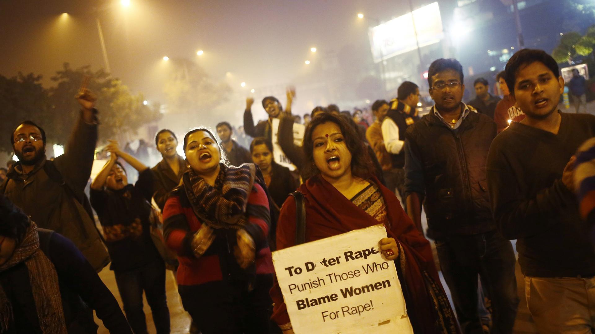 Demonstrators shout slogans during a candlelight vigil in Delhi
