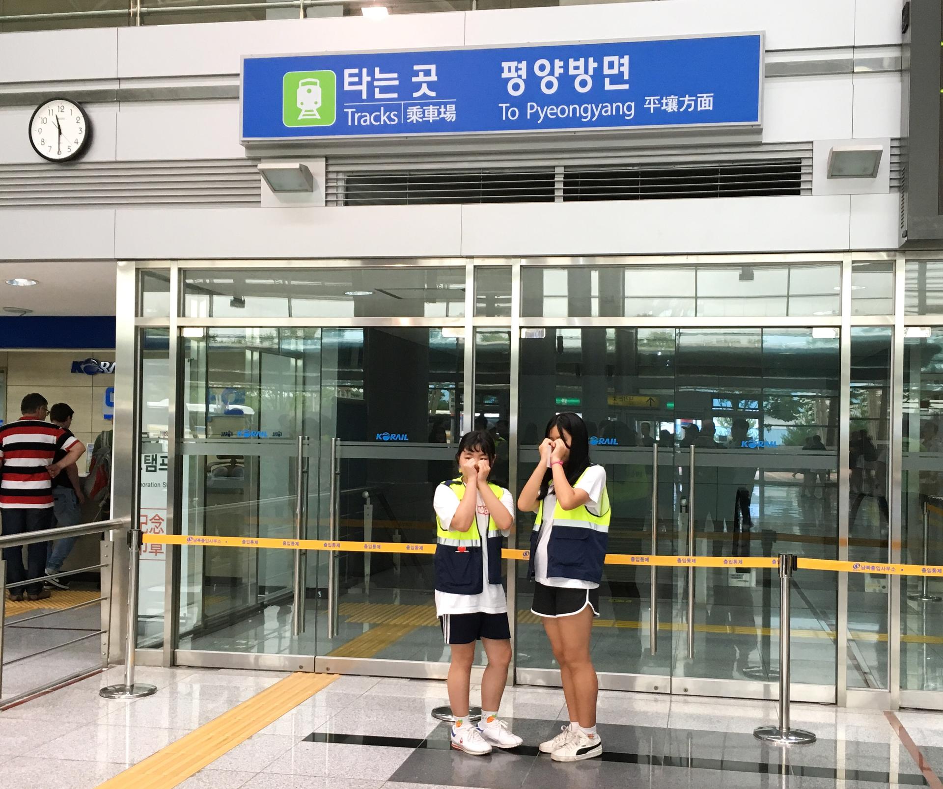 To women pose for photos at the Dorasan station