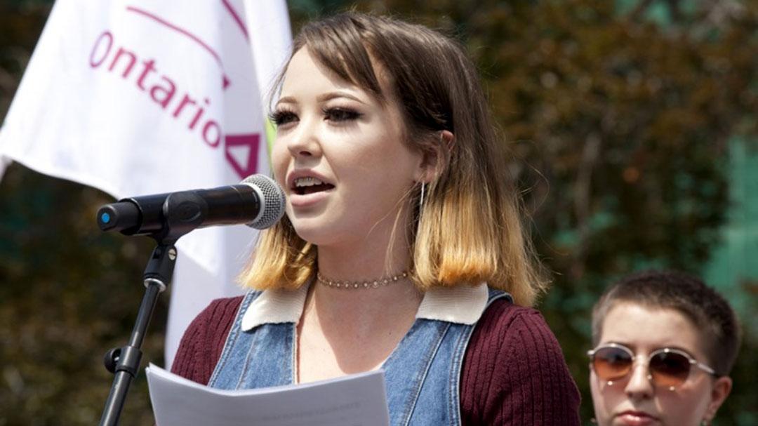 A young woman speaks at a microphone