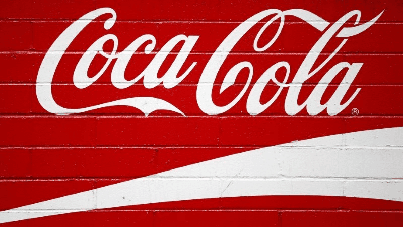 coca cola logo painted on a brick wall