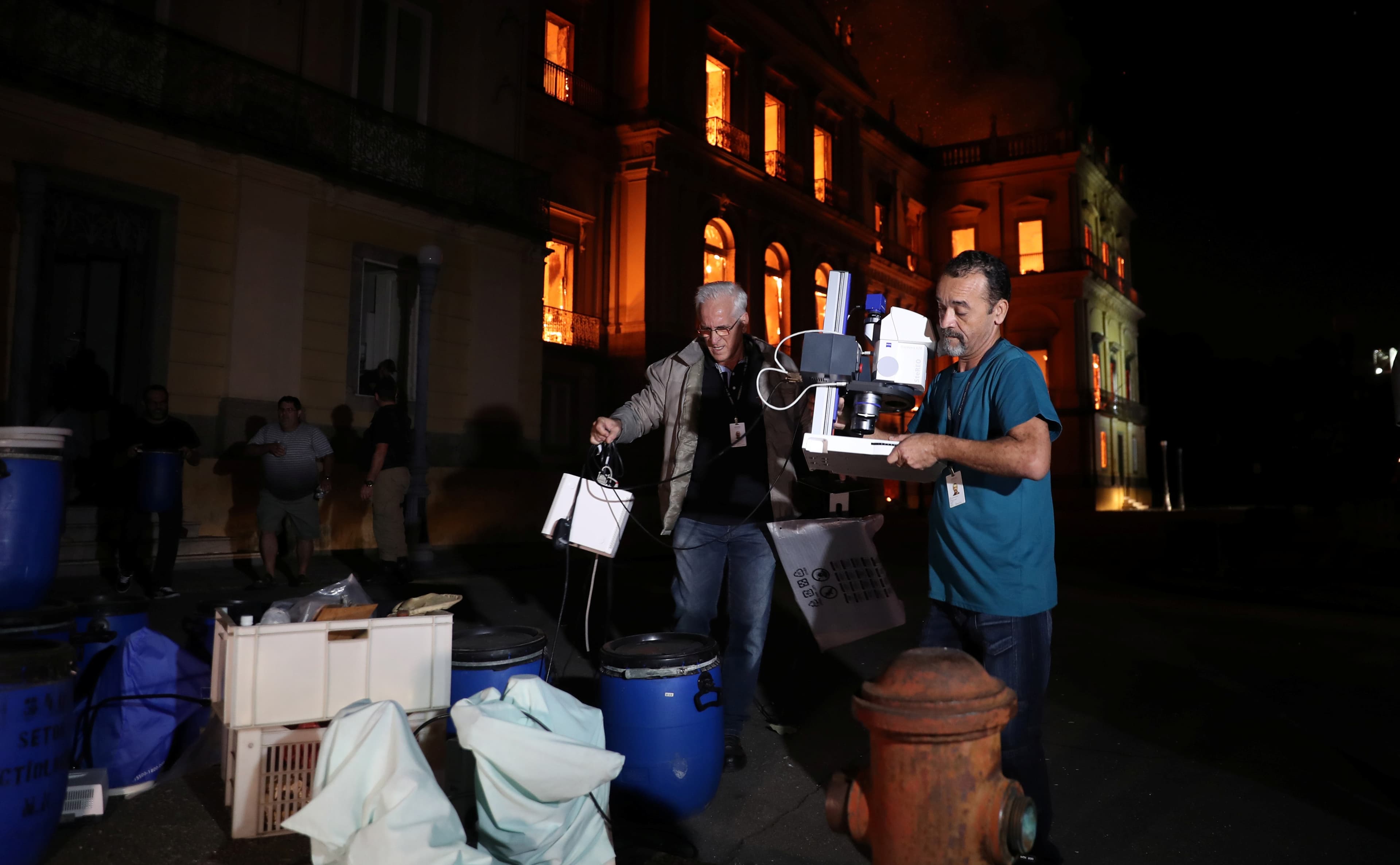 People rescue items during a fire