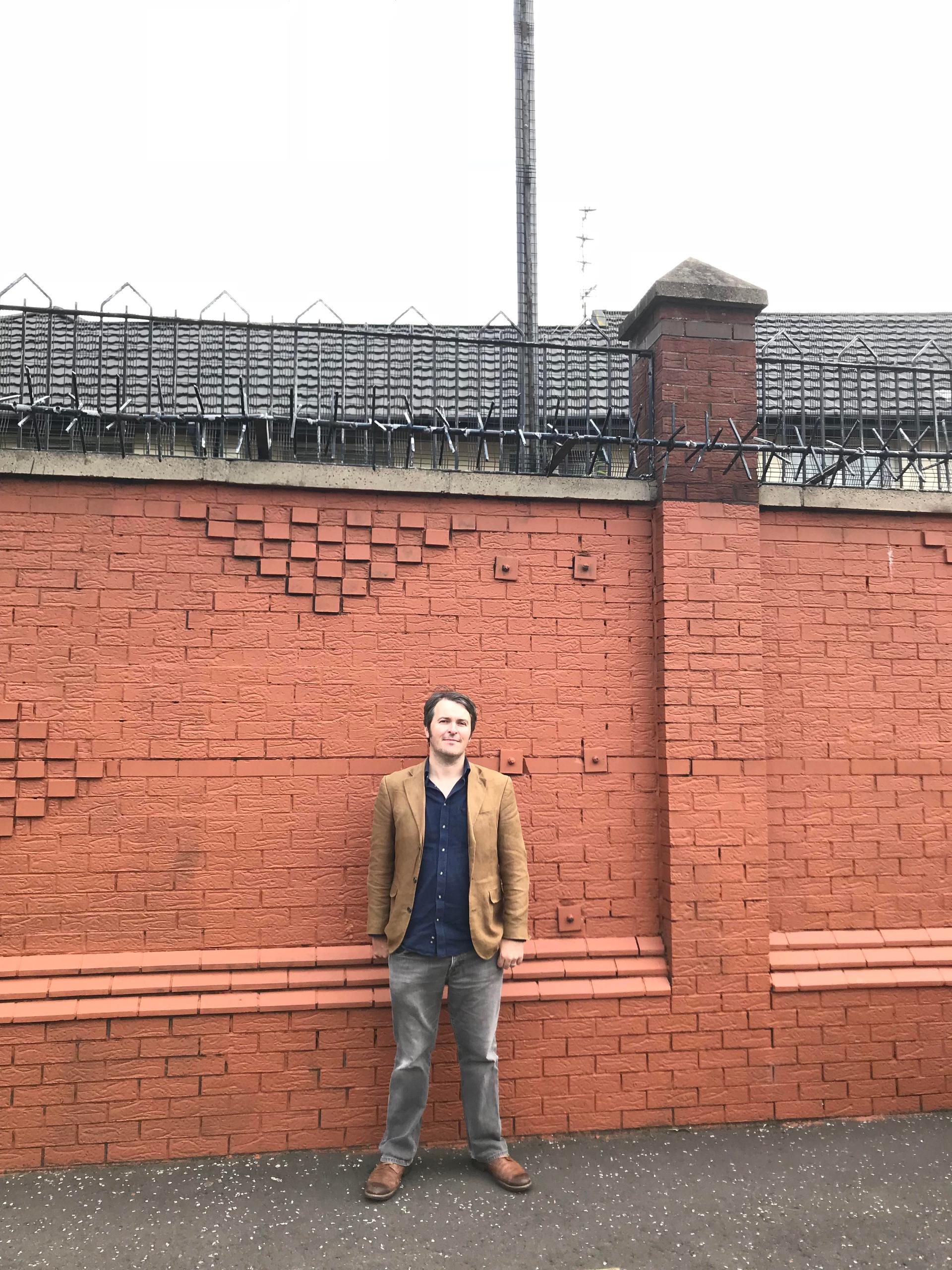 The writer Garrett Carr, standing by one of Belfast's numerous 'peace walls'