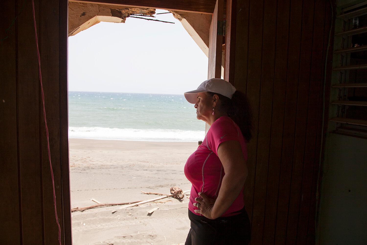 Rosa Elena Mastache Dominguez looks out of a door in her family home that now opens up to the beach