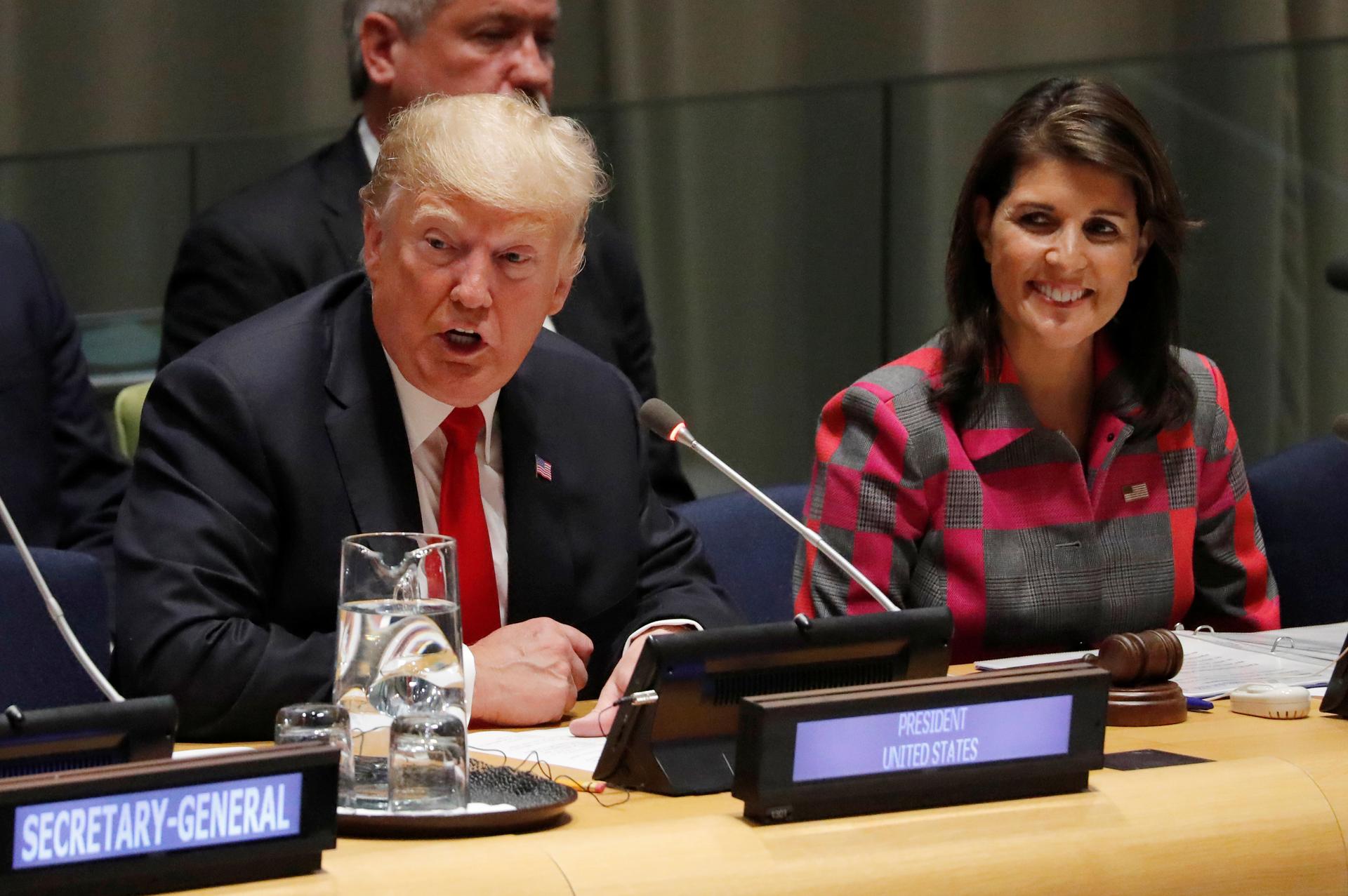 US President Donald Trump speaks as UN Ambassador Nikki Haley looks on
