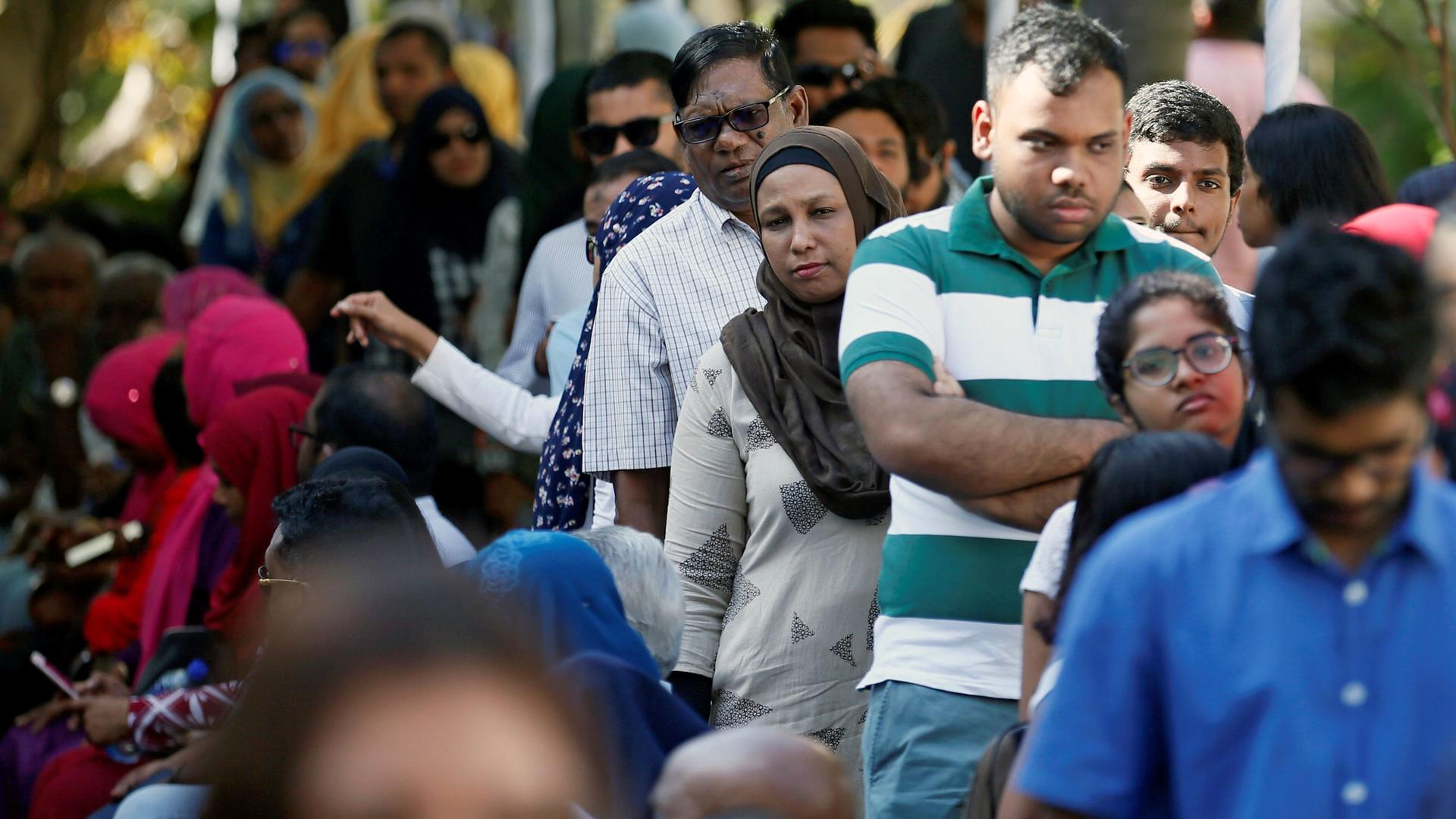 A crowd of people fill a street waiting on line to vote in Sri Lanka