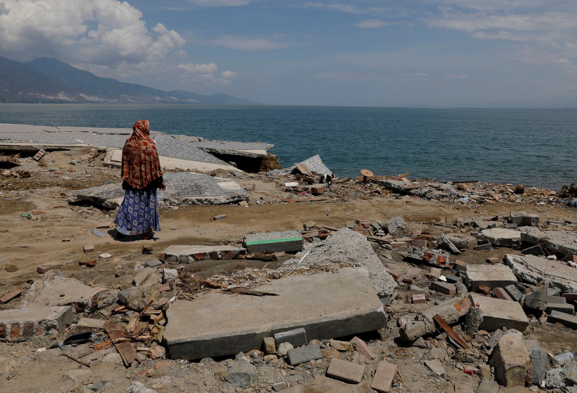 A woman wearing a head covering looks out on the ocean after a tsunami in Indonesia's Sulawesi Island..