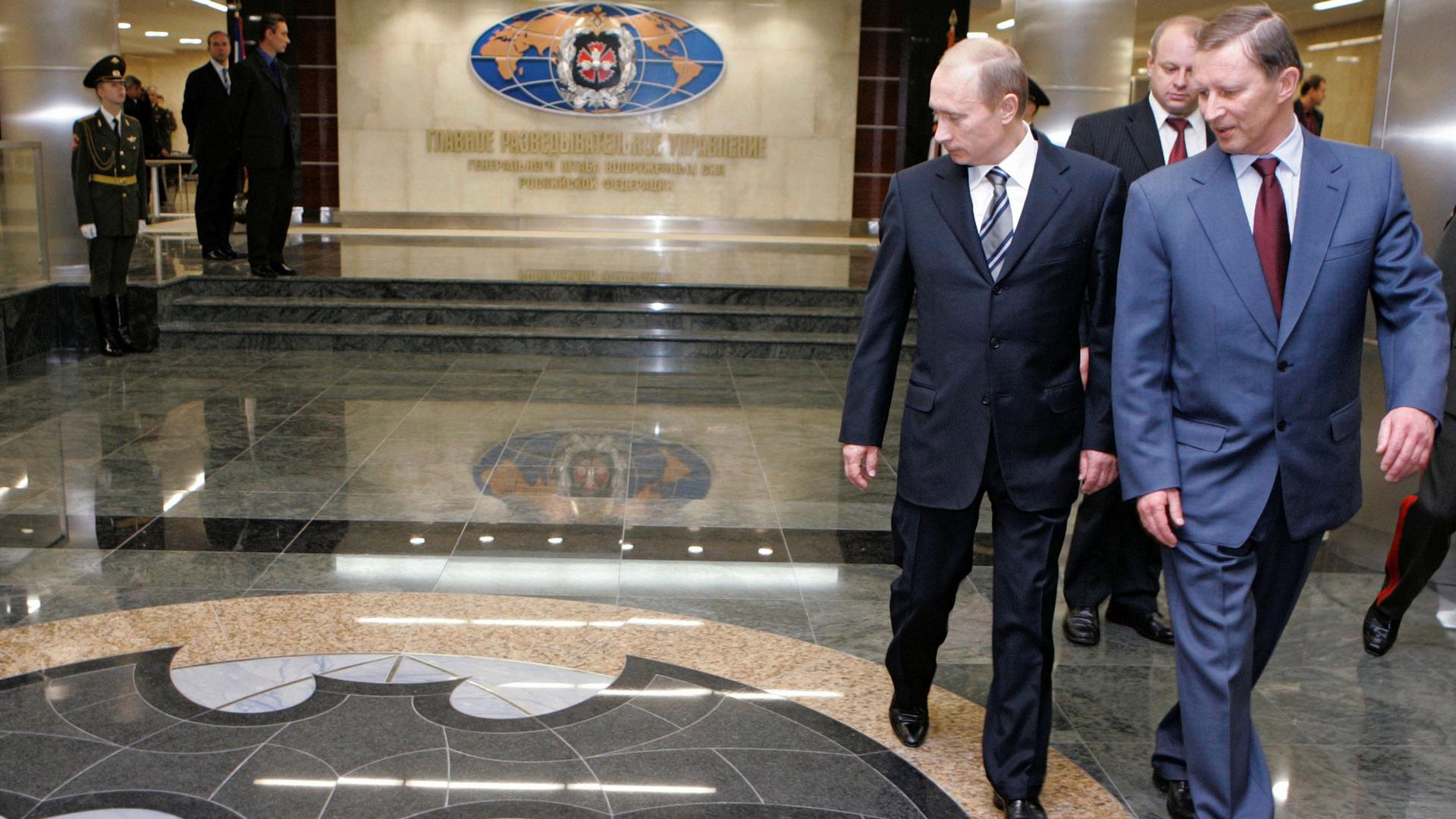 Russian President Vladimir Putin and Defense Minister Sergei Ivanov are shown walking past a marble floor depicting a bat at the new GRU military intelligence headquarters building in Russia. 