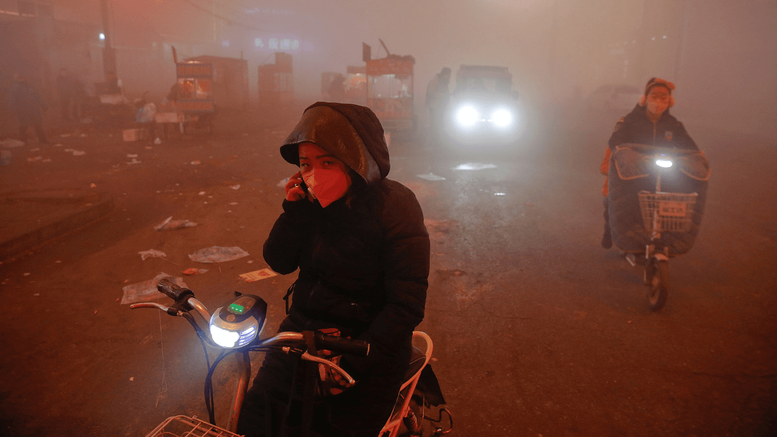 people ride motorcycles through heavy pollution in china