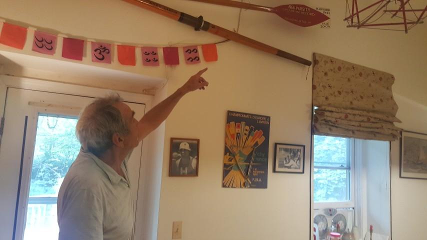 Andrew Larkin points to an oar hanging above his doorframe