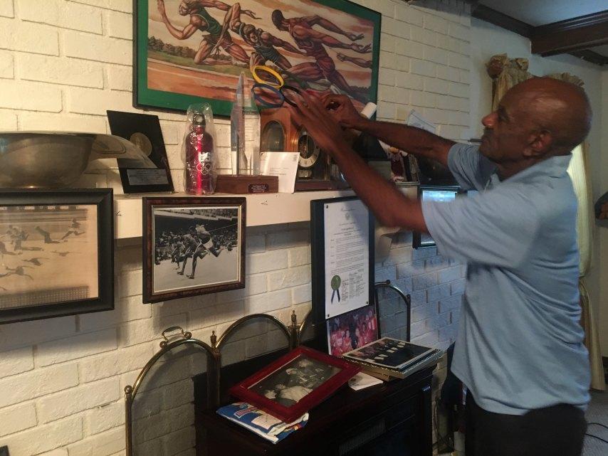 Leo Coleman places photos, paintings and medals over his fireplace
