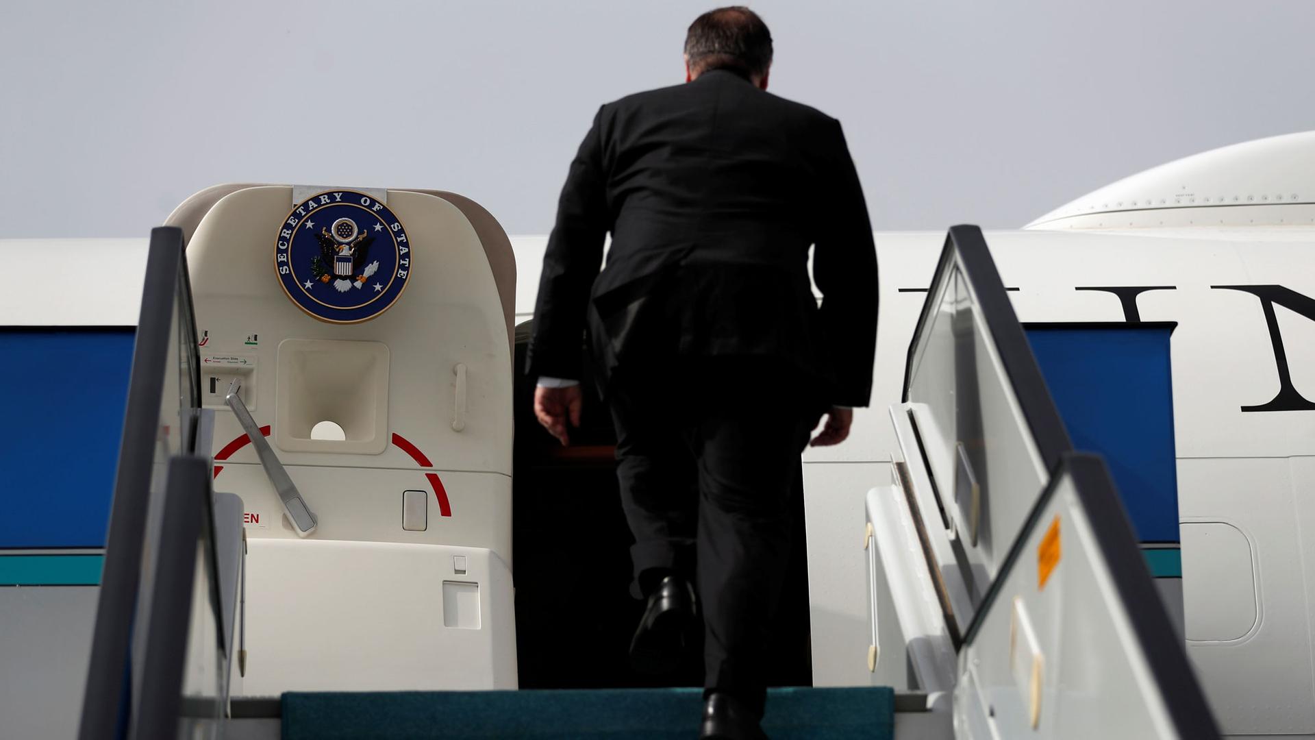 US Secretary of State Mike Pompeo is seen walking up the staircase leading to his plane emblazoned with the Secretary of State logo.