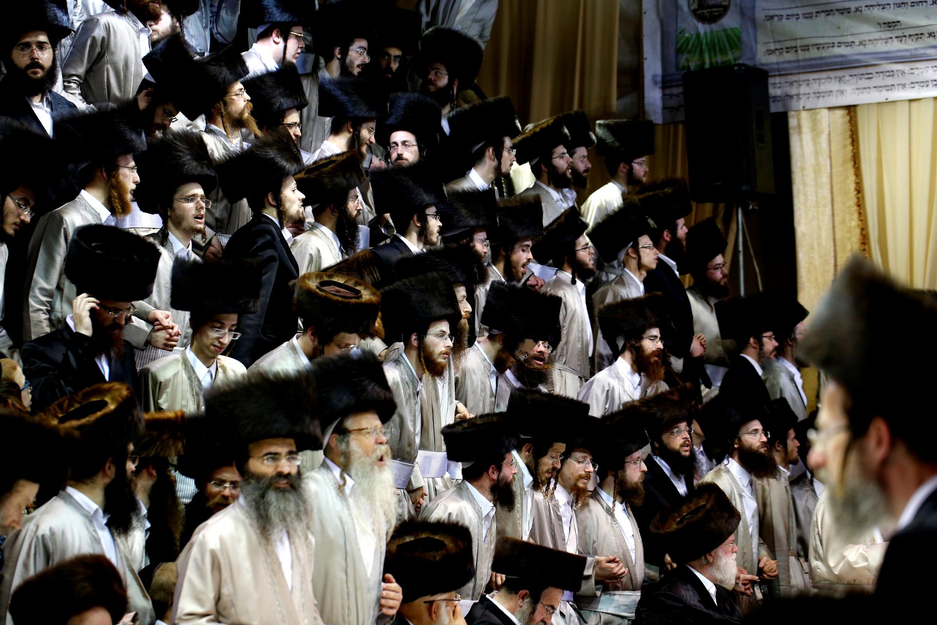 a large group of ultra-orthodox men dressed in traditional garb