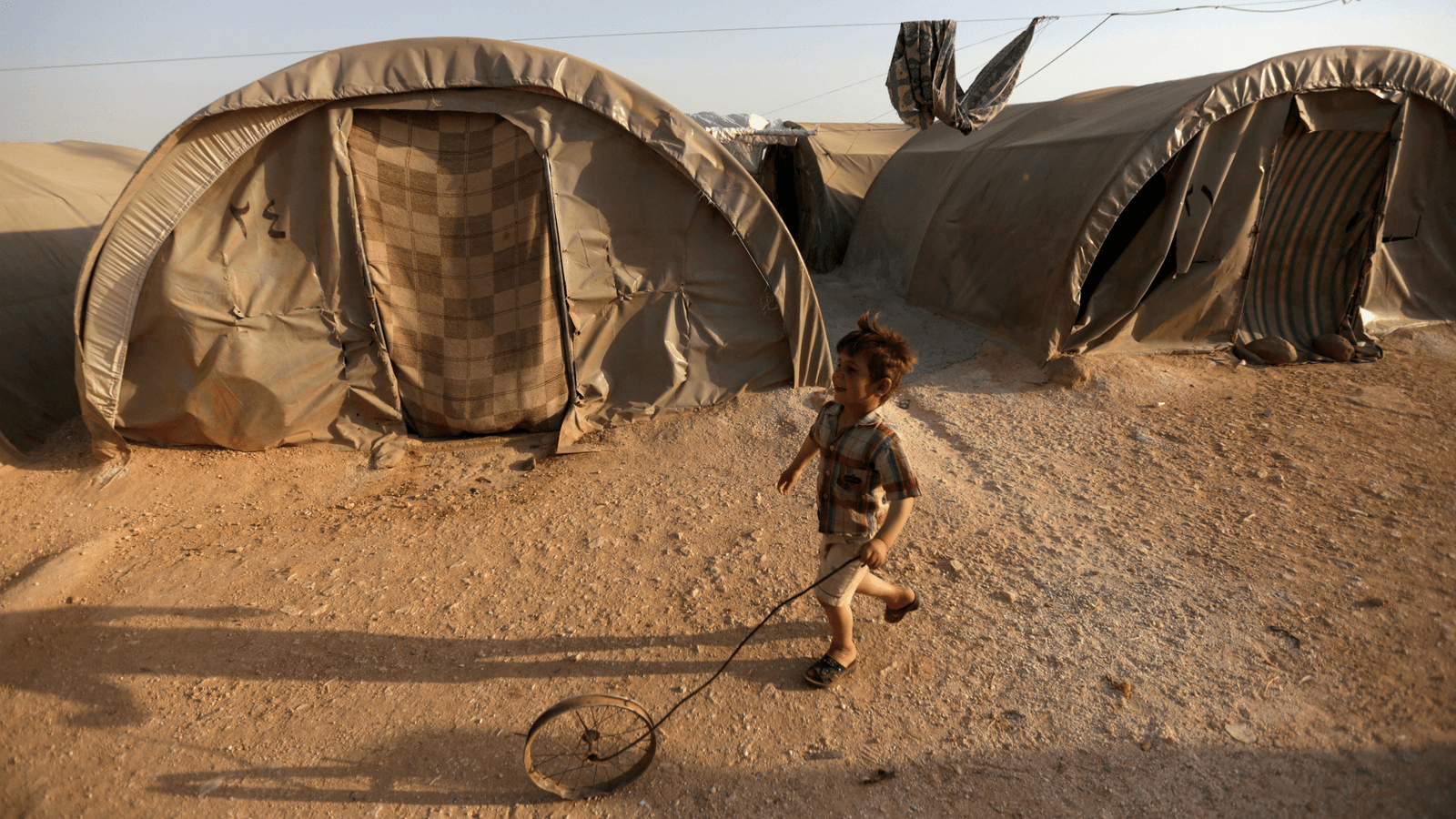 a child plays at a camp in Idlib, Syria