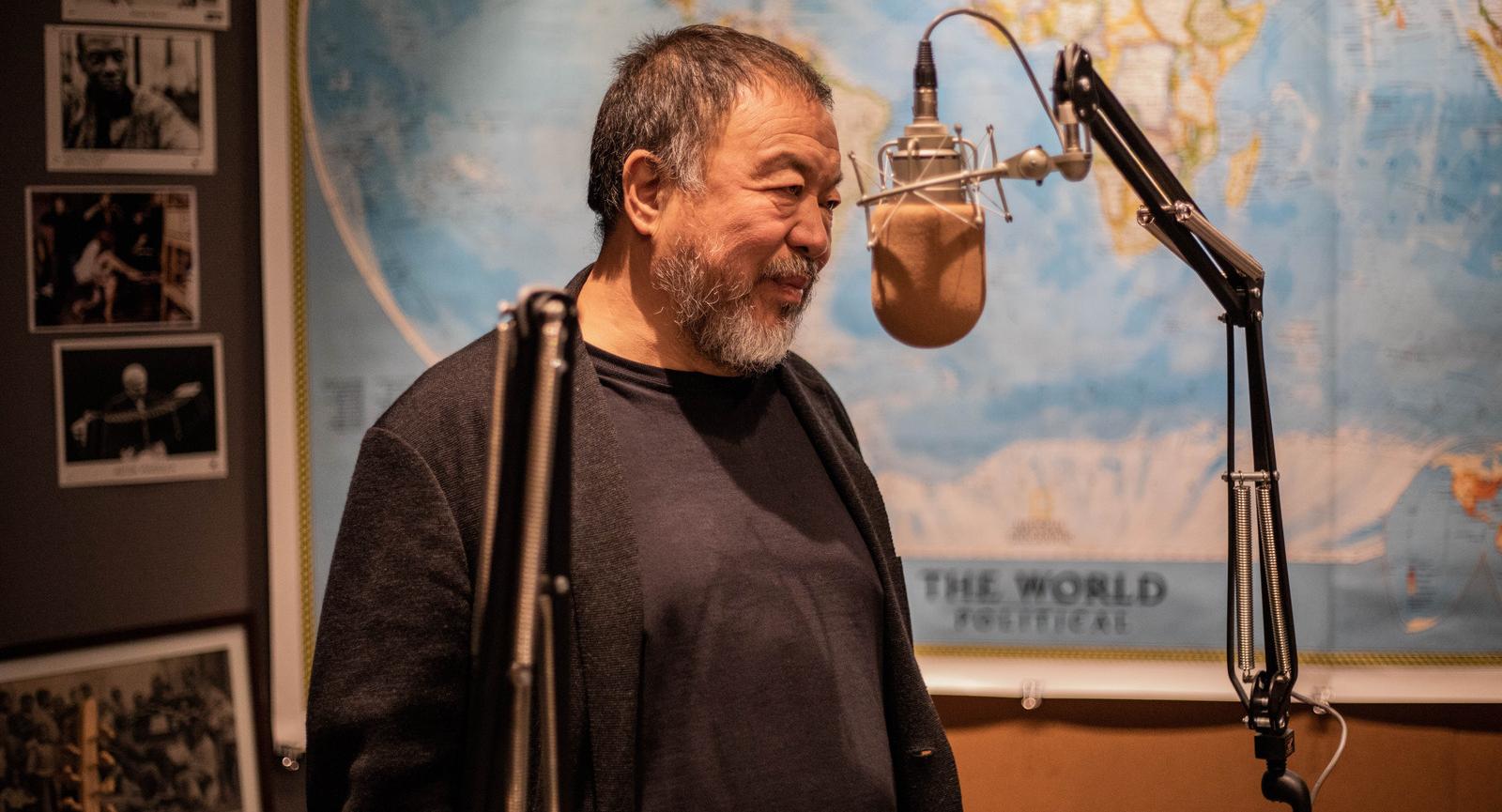 Chinese artist Ai Weiwei stands near a microphone in a radio studio. 