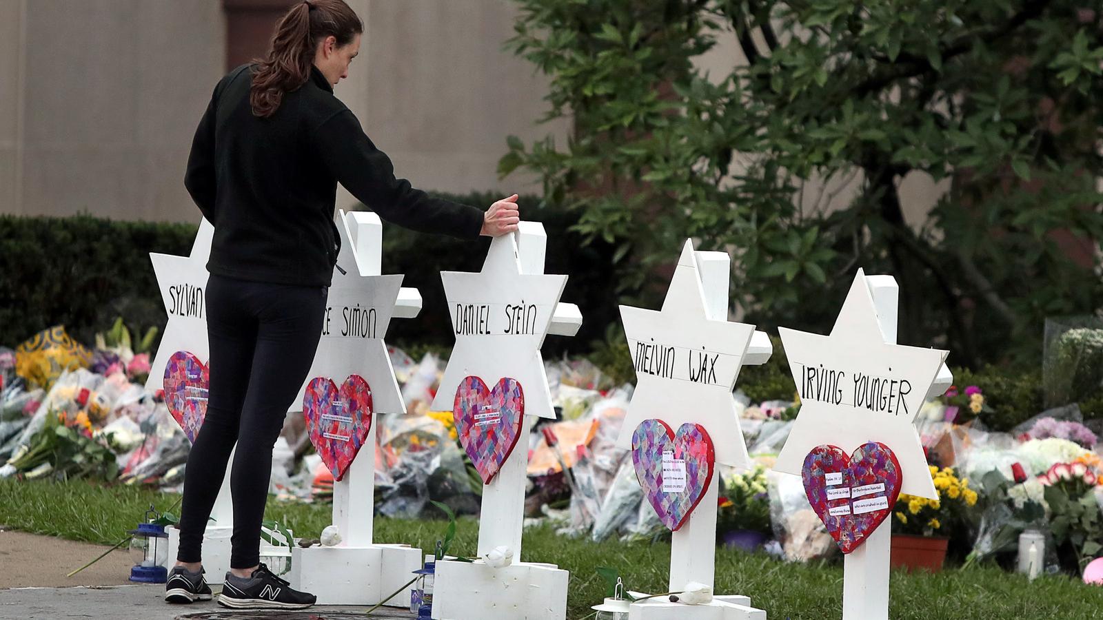 A woman touches a white Jewish star memorial for Tree of Life victim 