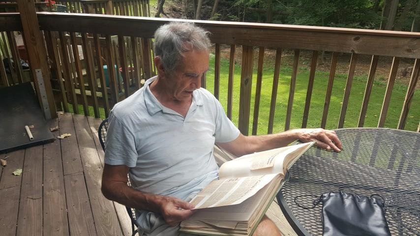 Andrew Larkin looks through his scrapbook on his back porch