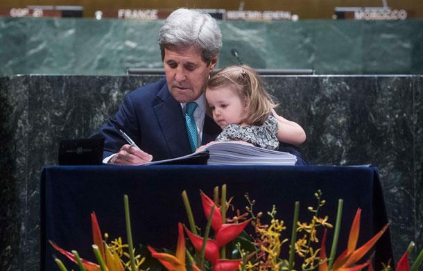John Kerry signs Paris Climate Agreement holding granddaughter