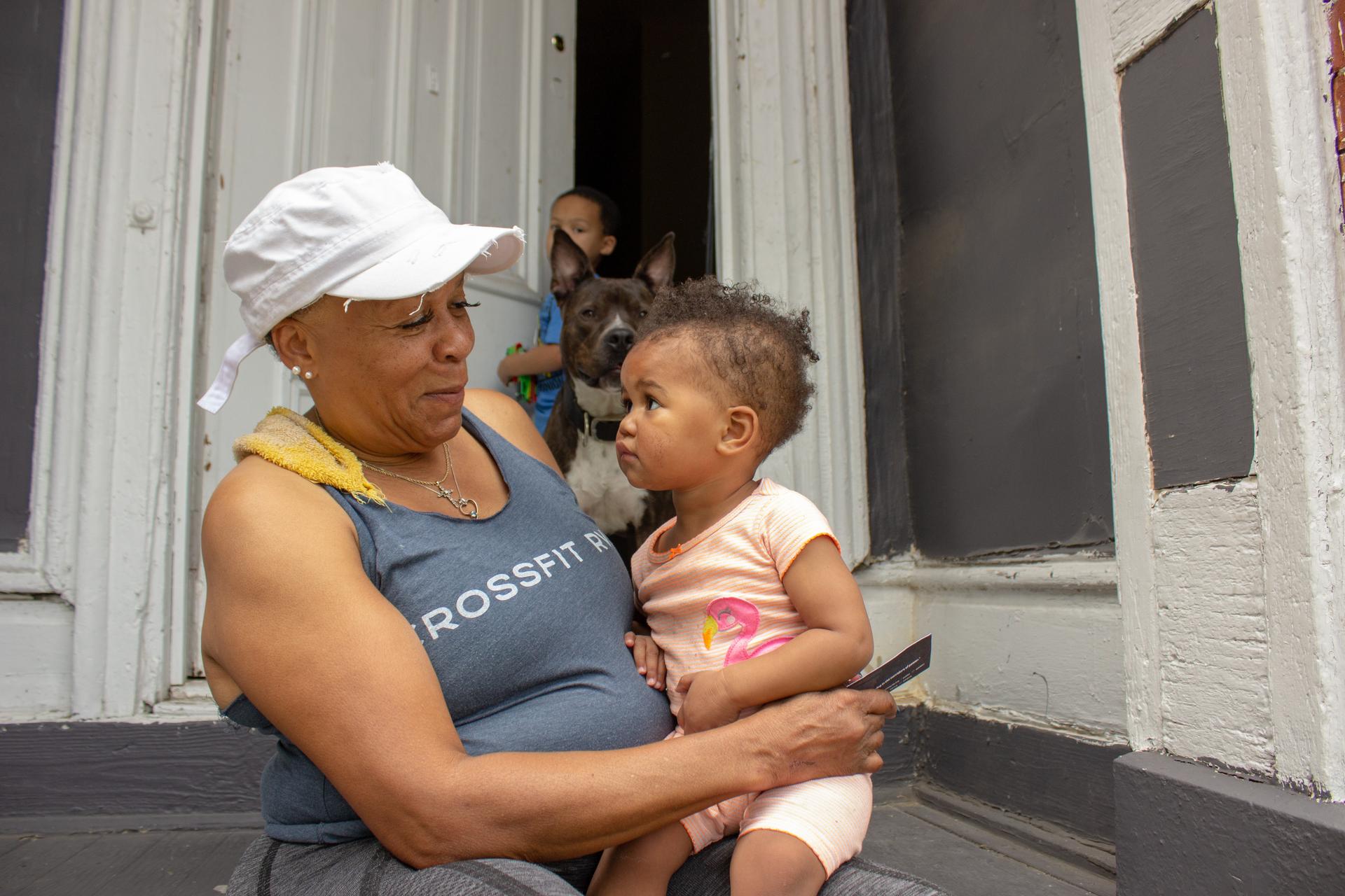 a grandmother and her grandchild in front of a house