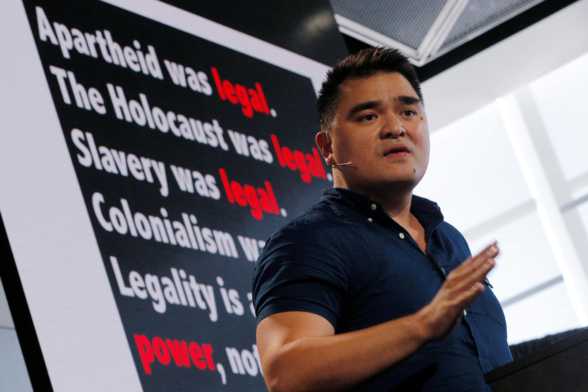 Jose Antonio Vargas speaks in front of a black background with white lettering 