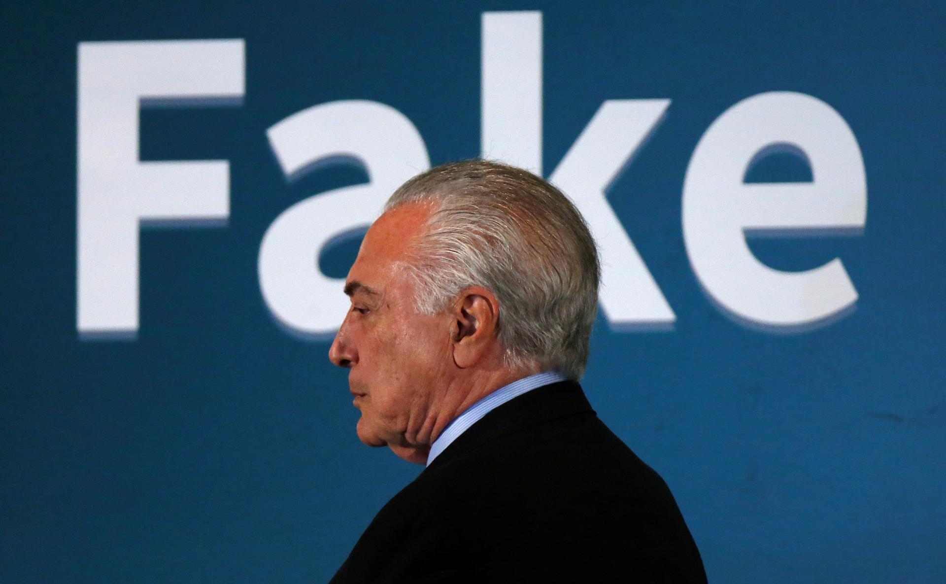 Brazil's President Michel Temer with "FAKE" spelled out behind his head 