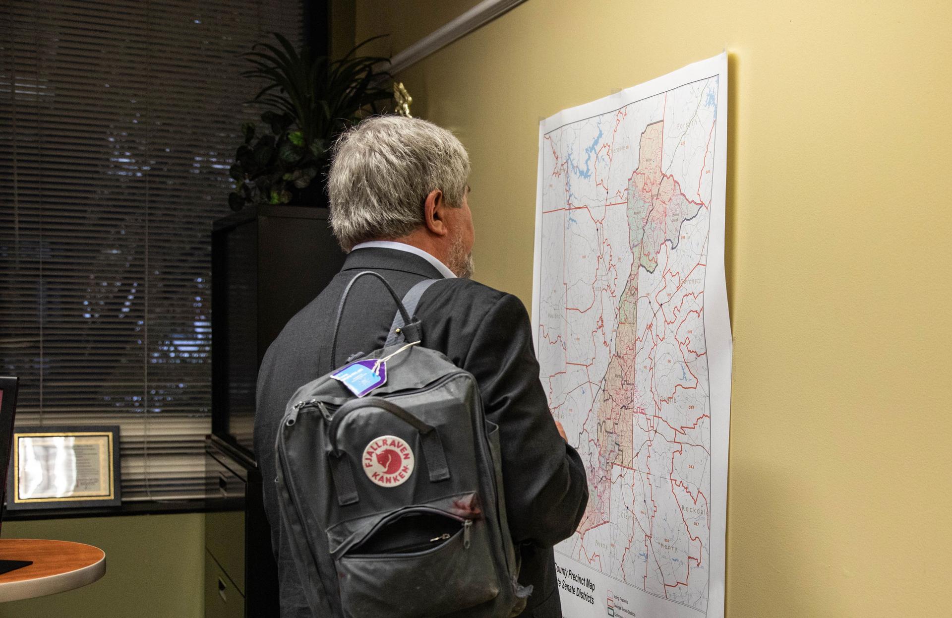 A man inspects a map of Georgia's voting districts.