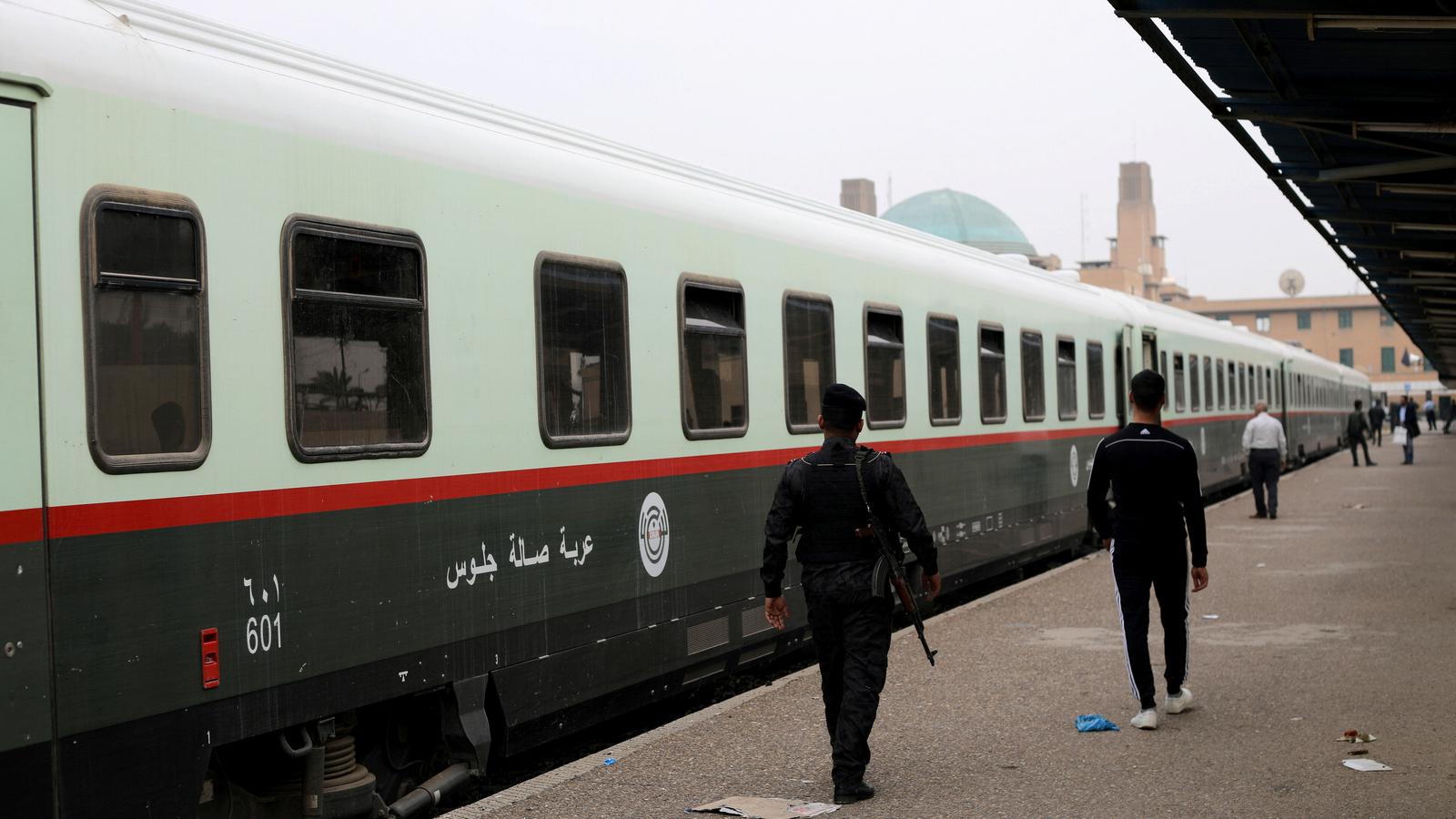 Passengers walk on a platform before boarding a train to Fallujah. 