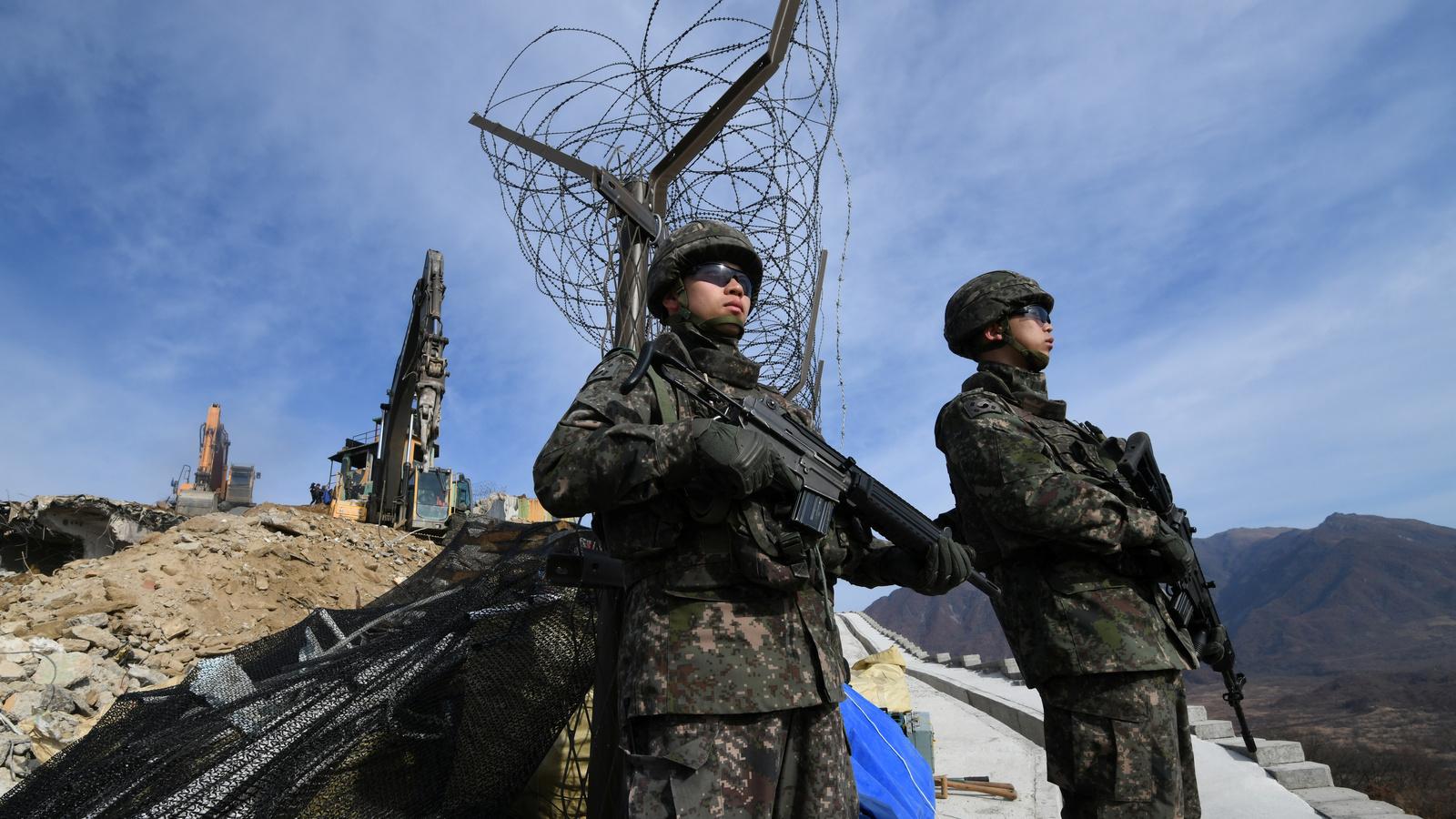 South Korean soldiers stand guard as construction equipment destroys a guard post in the Demilitarized Zone dividing the two Koreas in Cheorwon, Nov. 15, 2018. 