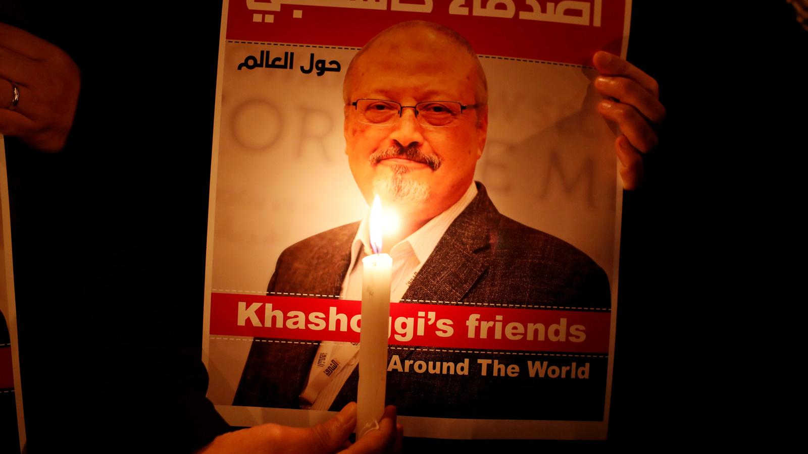 Poster with a picture of Saudi journalist Jamal Khashoggi lit up by candelight. 
