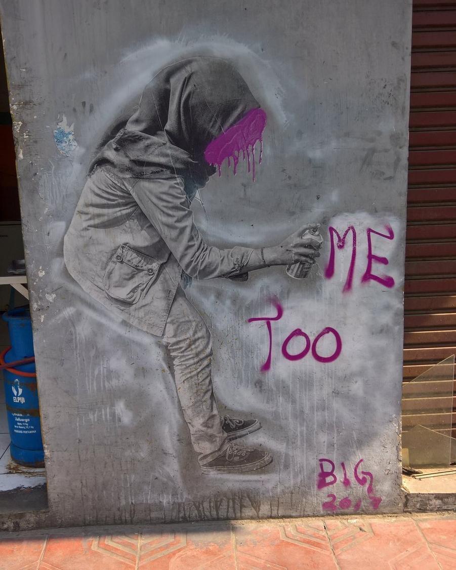 Depiction of girl wearing a hijab sprays 'me too' in pink letters