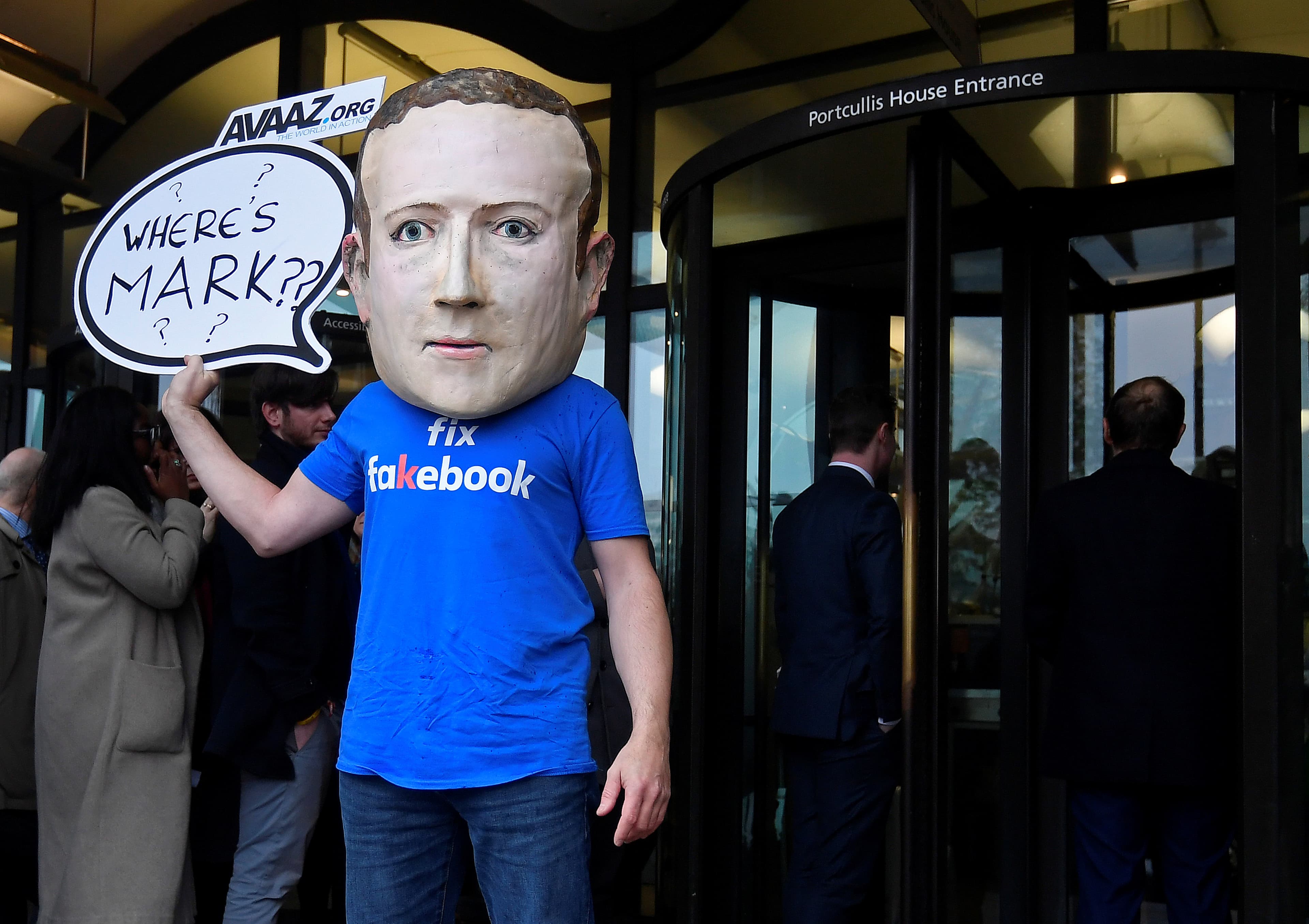 A campaigner from a political pressure group wears an oversized mask of founder and CEO of Facebook Mark Zuckerberg