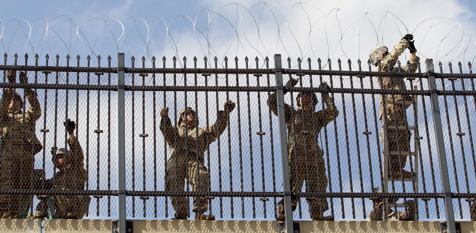US soldiers install a razor wire fence along US-Mexico border. 