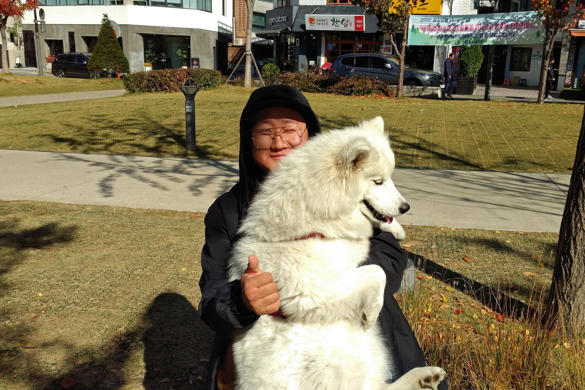 Kim Jong-yoon hugs a white dog.
