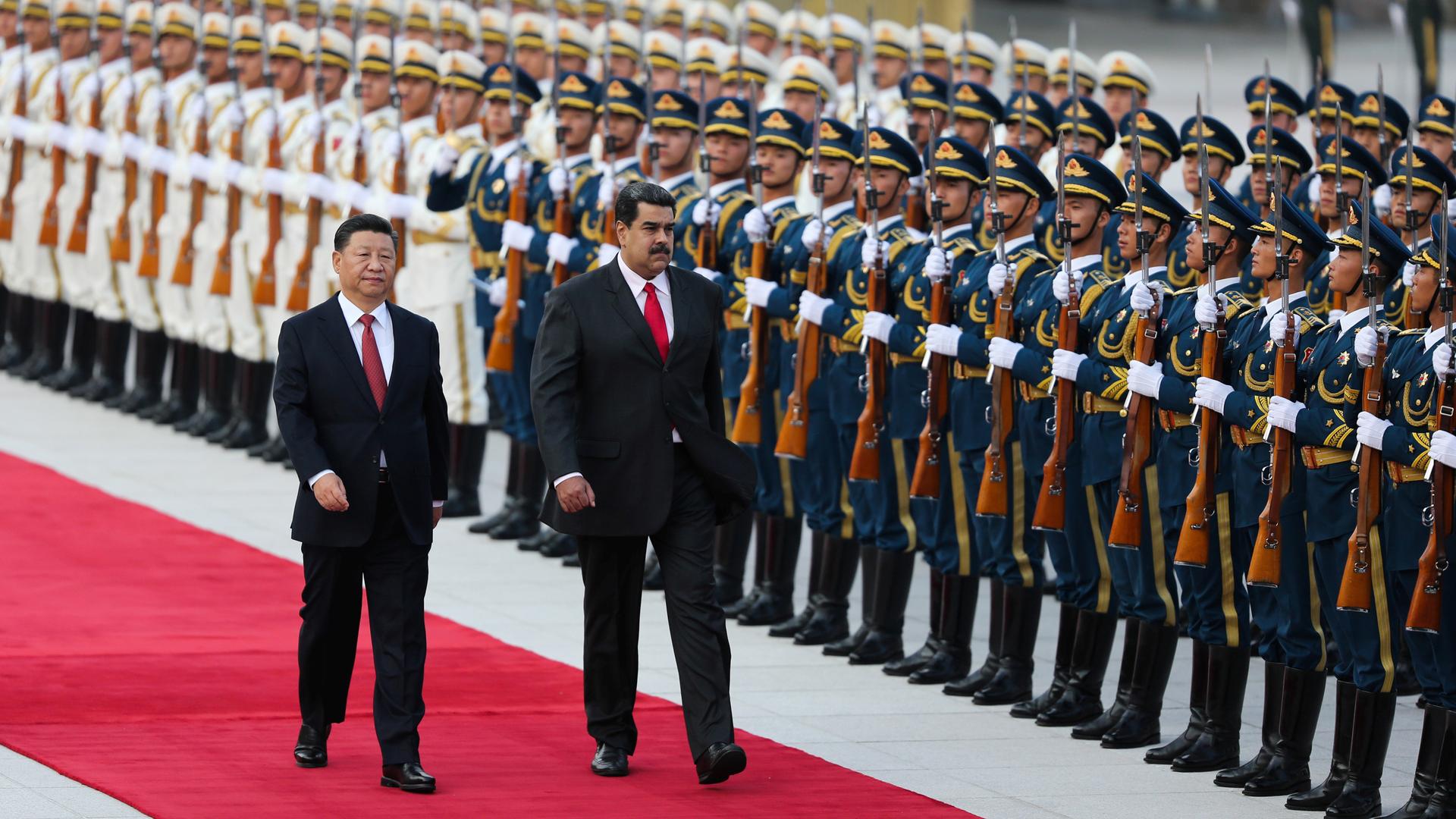 Chinese President Xi Jinping walks next to Venezuela's President Nicolas Maduro in front of a row of Chinese troops 