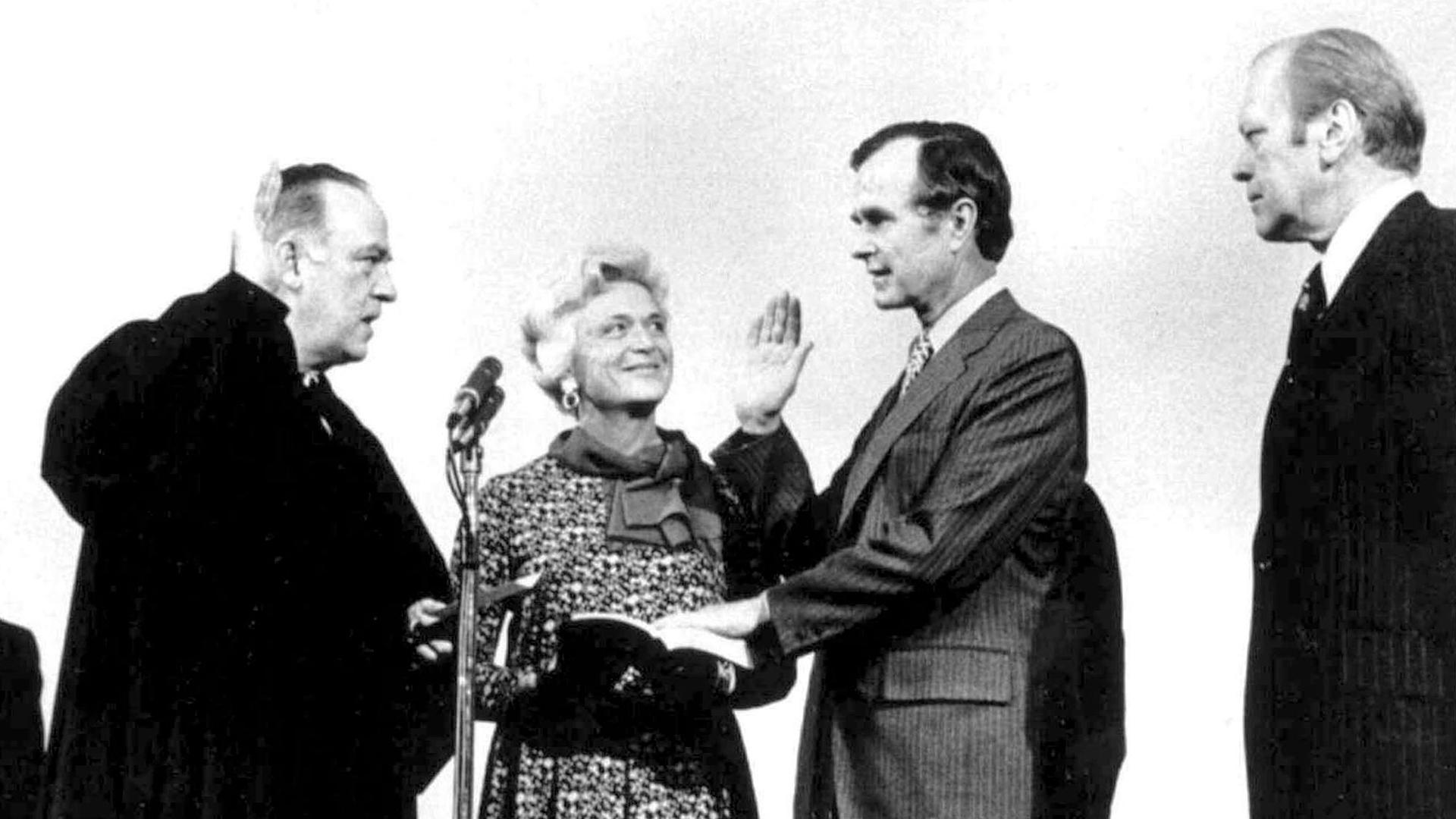George H. W. Bush is shown with his hand on the bible nad right hand raised being sworn in as director of CIA.