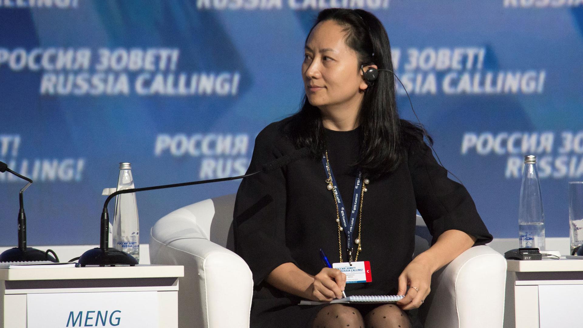 Meng Wanzhou, wearing all black, is shown seated with a pen and notepad at a session of the VTB Capital Investment Forum "Russia Calling!" in Moscow, Russia, 2014. 
