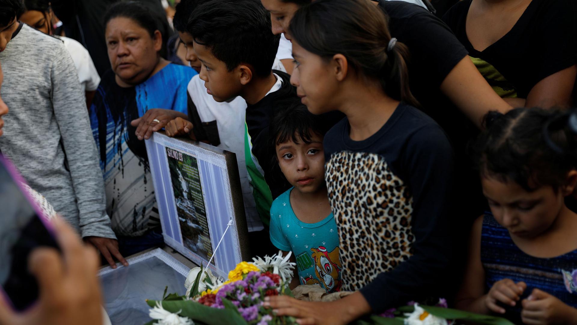People crowd next to the coffin with a young person in a blue shirt with a tear in their eye, during her funeral, in Tegucigalpa, Honduras in July.