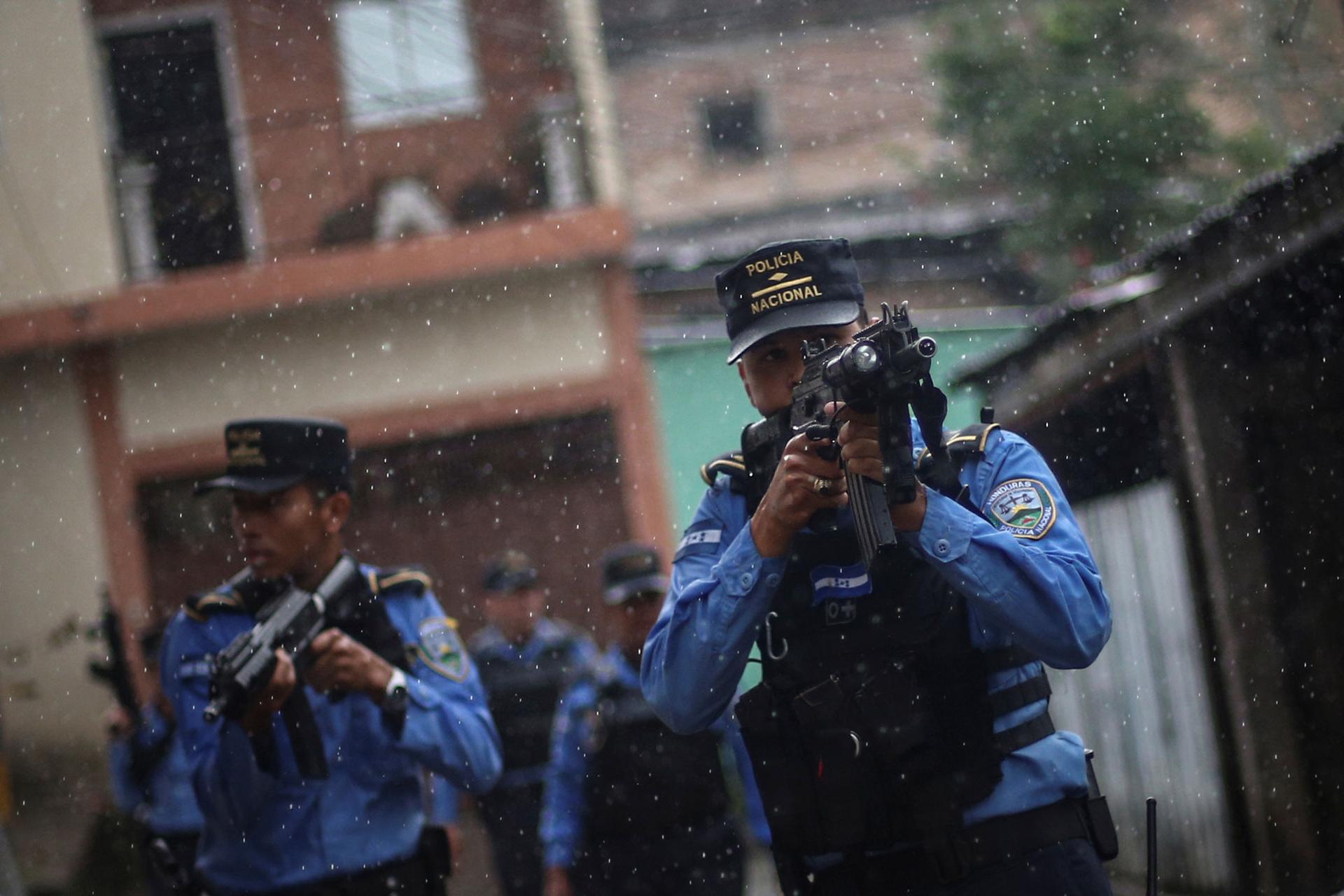 Several police officers are shown with high-powered riffles taking aim while on patrol .
