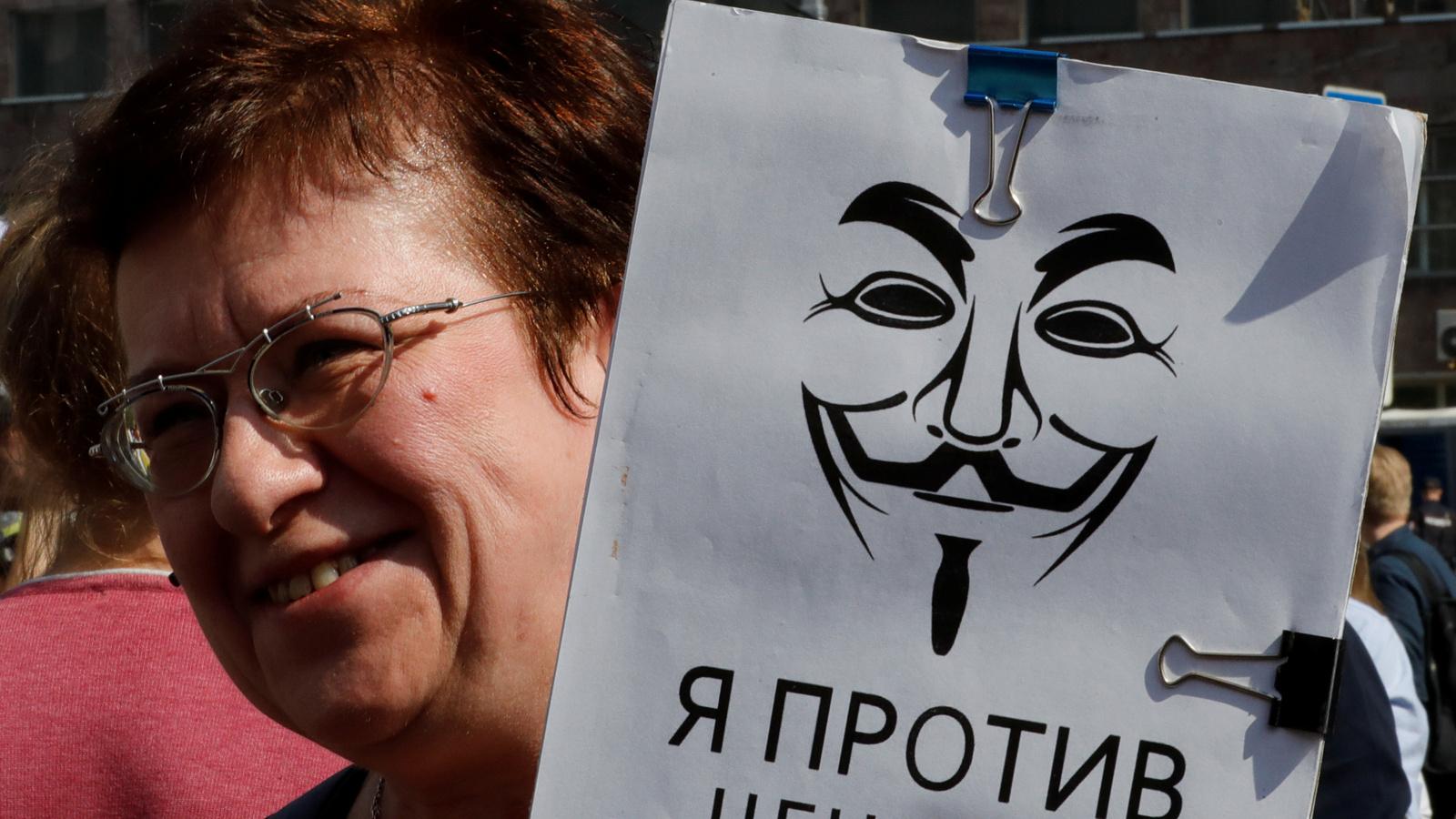 A woman holds a sign in Russian that says "I'm against censorship." 