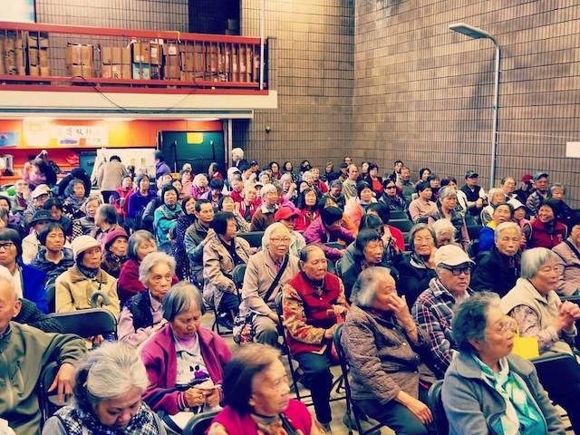 A room full of mostly elderly Asian residents of San Francisco's sit in a large room as they attend a talk on protecting themselves from immigration enforcement.