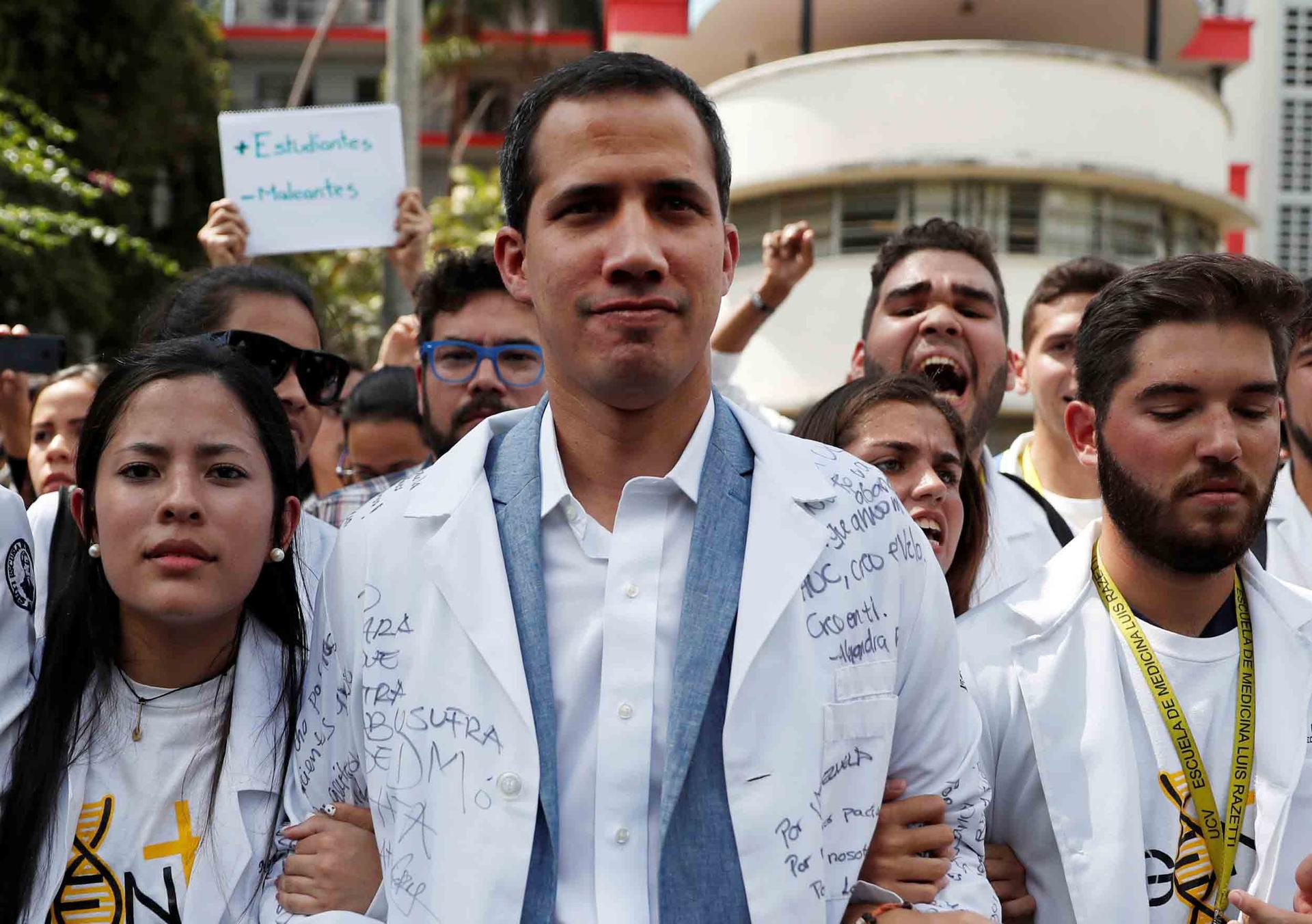 Juan Guaidó, center, stands with protesters wearing white