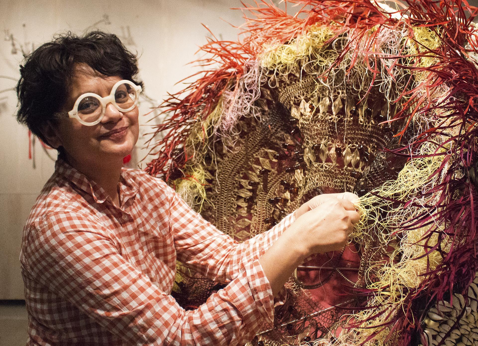 Rina Banerjee works on her sculpture “Excessive Flower.”