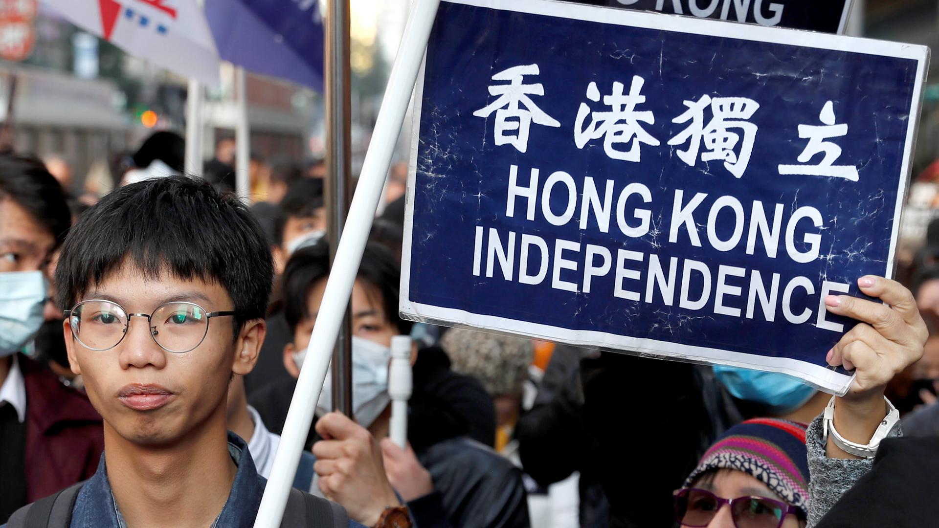 Protesters hold a sign calling for independence in Hong Kong.