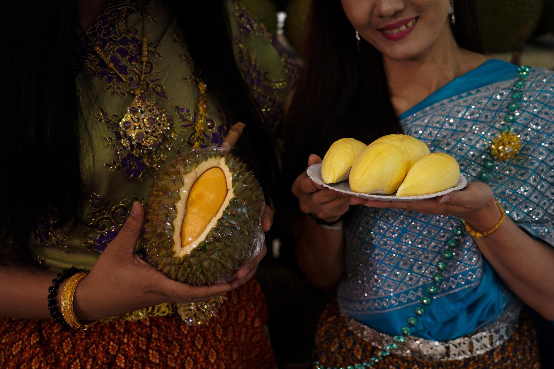 Women dressed in Thai traditional costumes hold durians at a department store in Bangkok