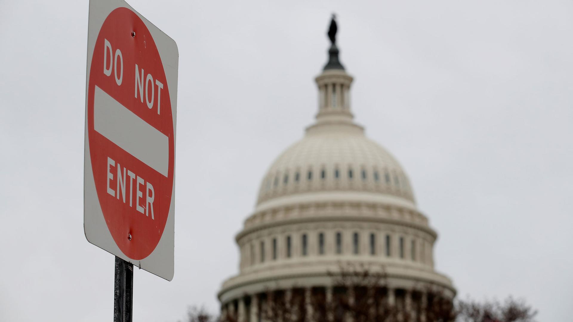 The top of the US Capitol building is show in the background with a 'Do not enter' sign shown in the nearground.