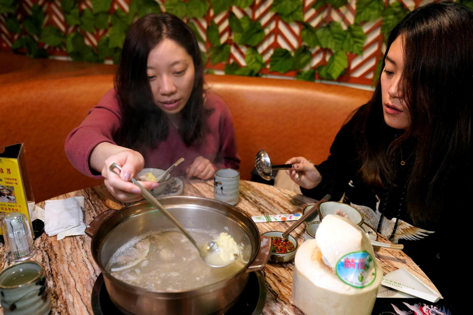 two women eating durian hot pot