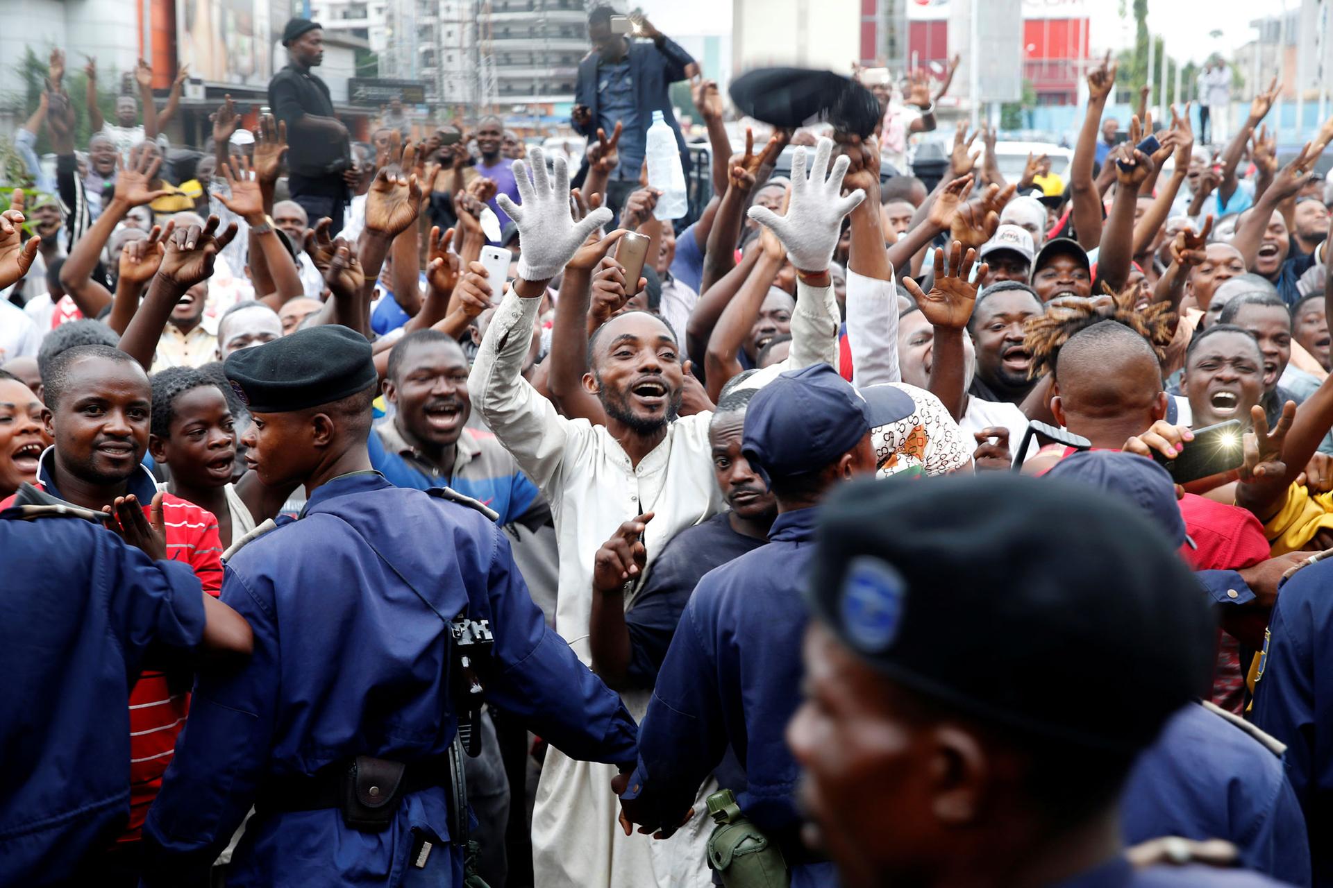 Supporters of Felix Tshisekedi are shown with their hands in the air celebrating in the streets of Kinshasa, Democratic Republic of Congo.