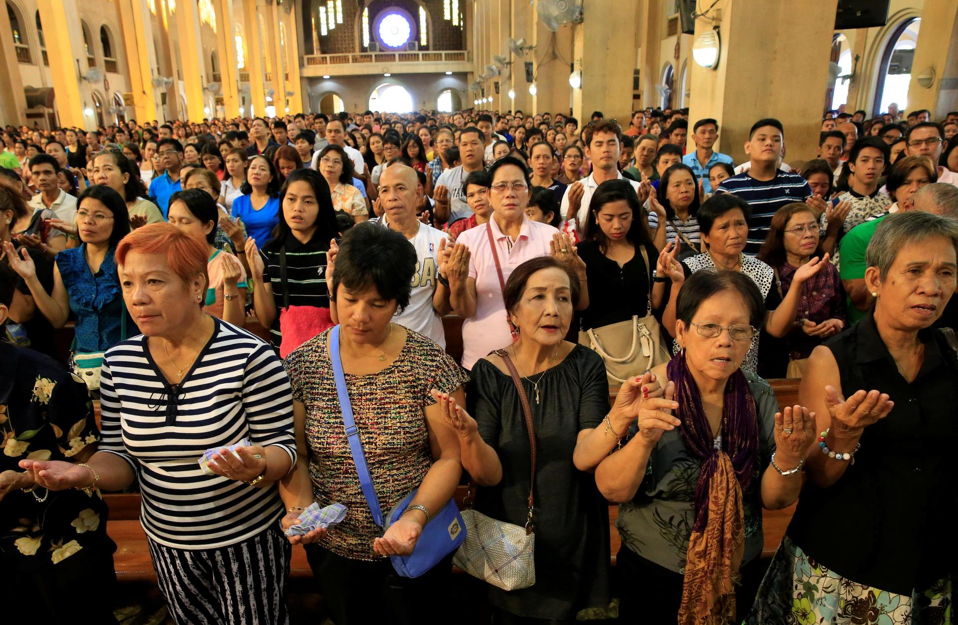 dozens of Filipino church goers praying