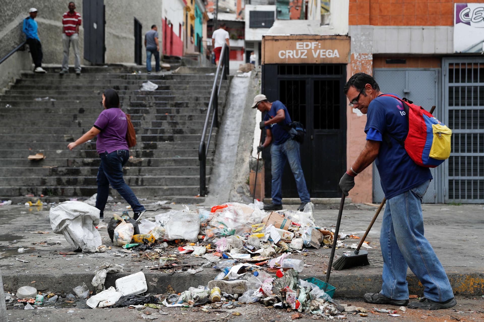 a man sweeps piles of litter