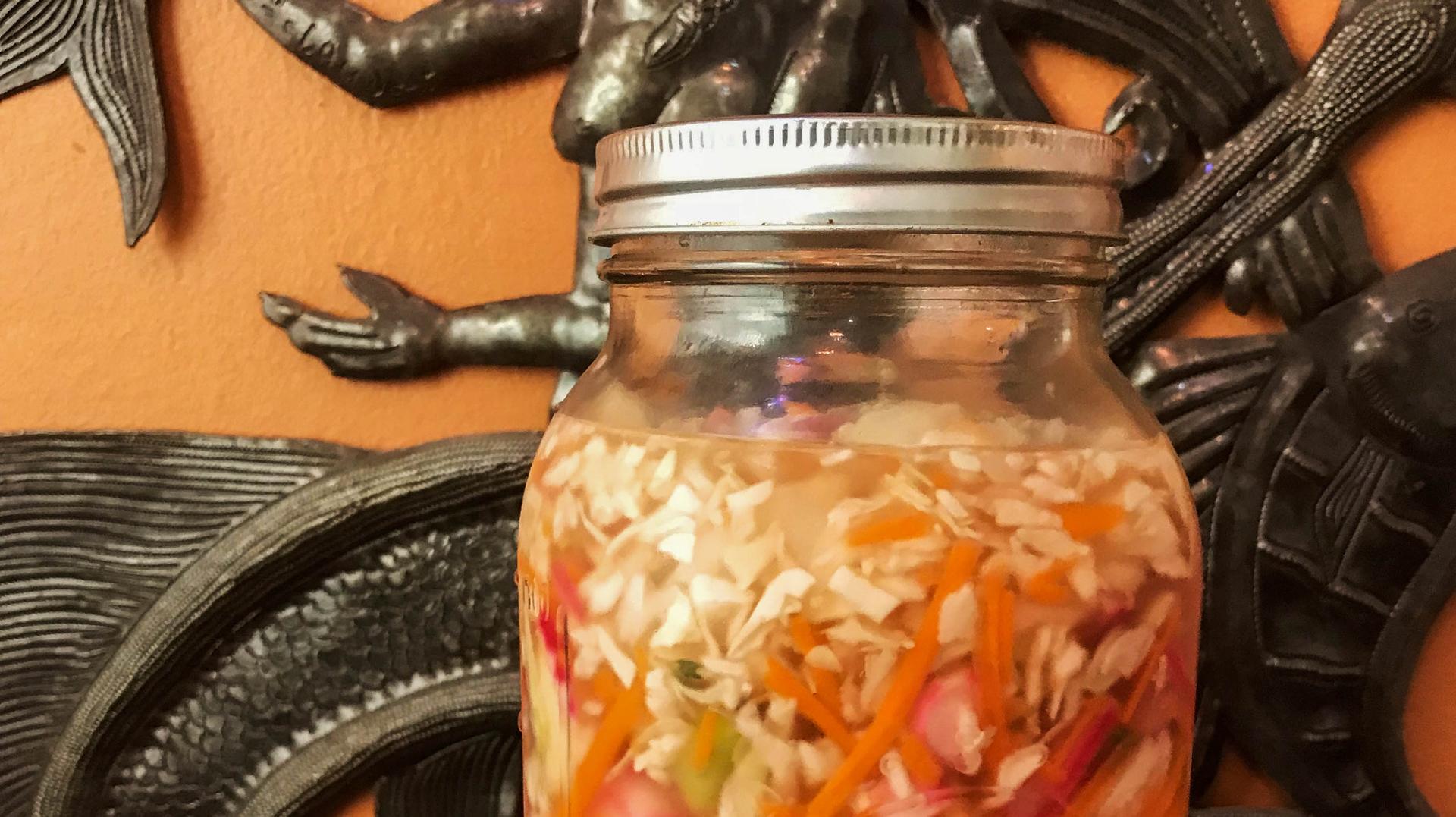 A close-up of a jar of pikliz. 