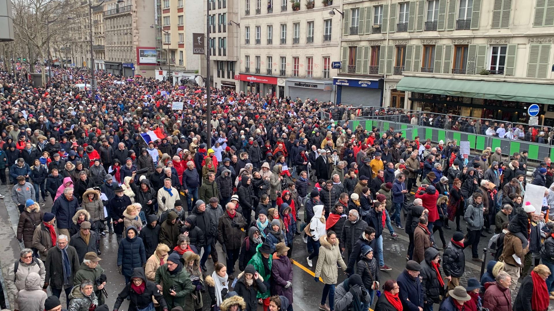 Thousands of people march wearing 'red scarves' against yellow vest movement.